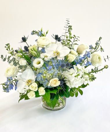 a vase filled with white and blue flowers