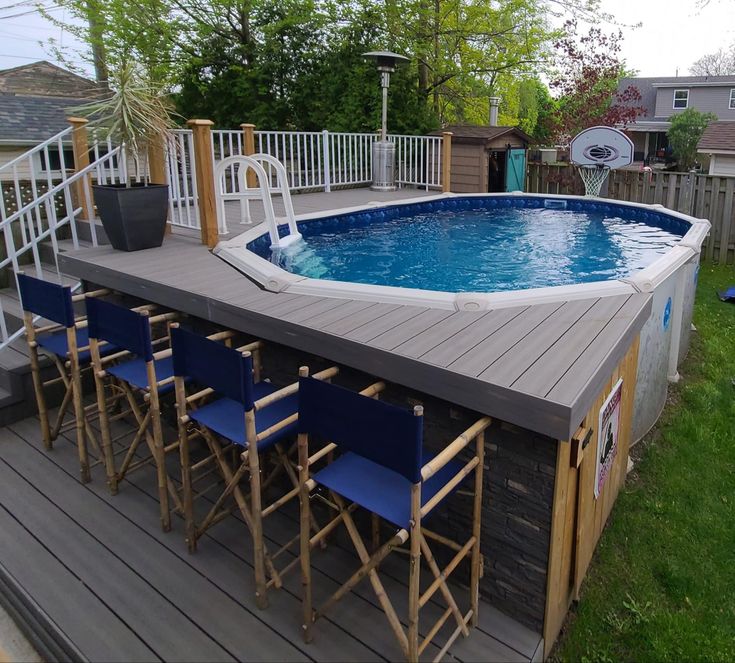 an above ground pool with chairs around it