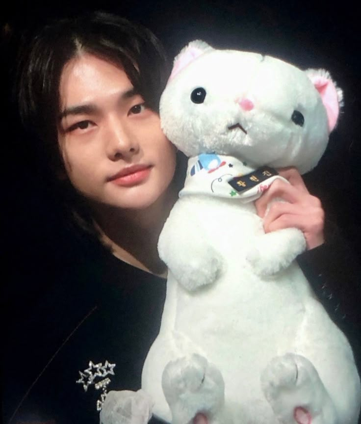 a man holding a white teddy bear in his hands