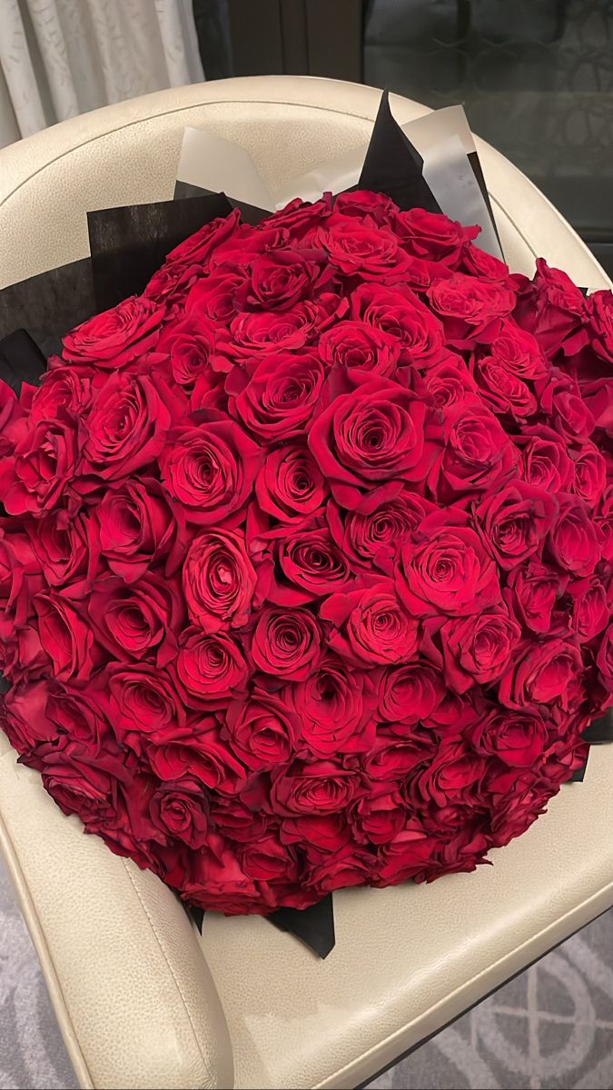 a large bouquet of red roses is sitting on a chair