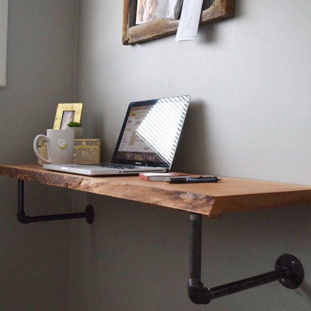 a laptop computer sitting on top of a wooden desk next to a cup of coffee