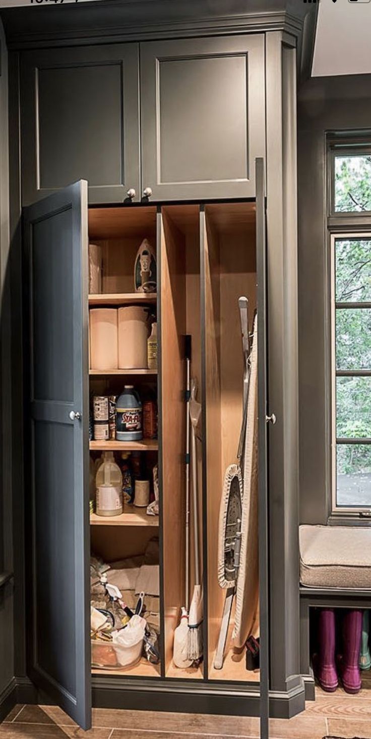 an open cabinet in a kitchen filled with cleaning supplies