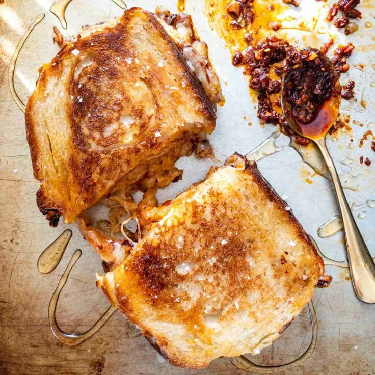 two pieces of grilled cheese sitting on top of a table next to a fork