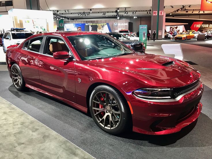 a red car is on display at an auto show