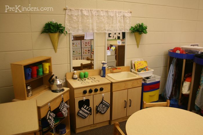 a child's play kitchen with wooden furniture