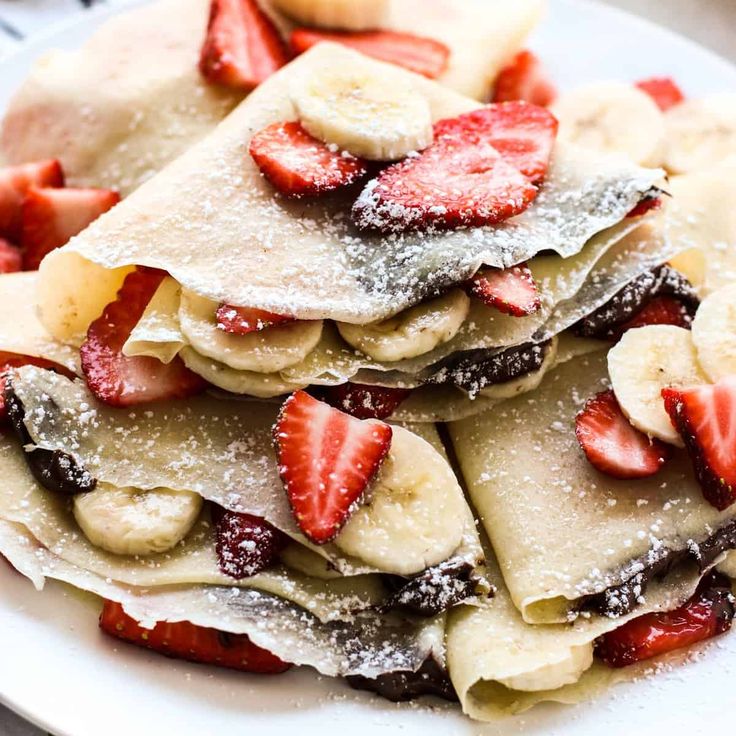 strawberry banana nutella crepes on a white plate