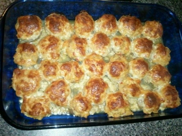 a casserole dish with meatballs and cheese in it on a blue plate