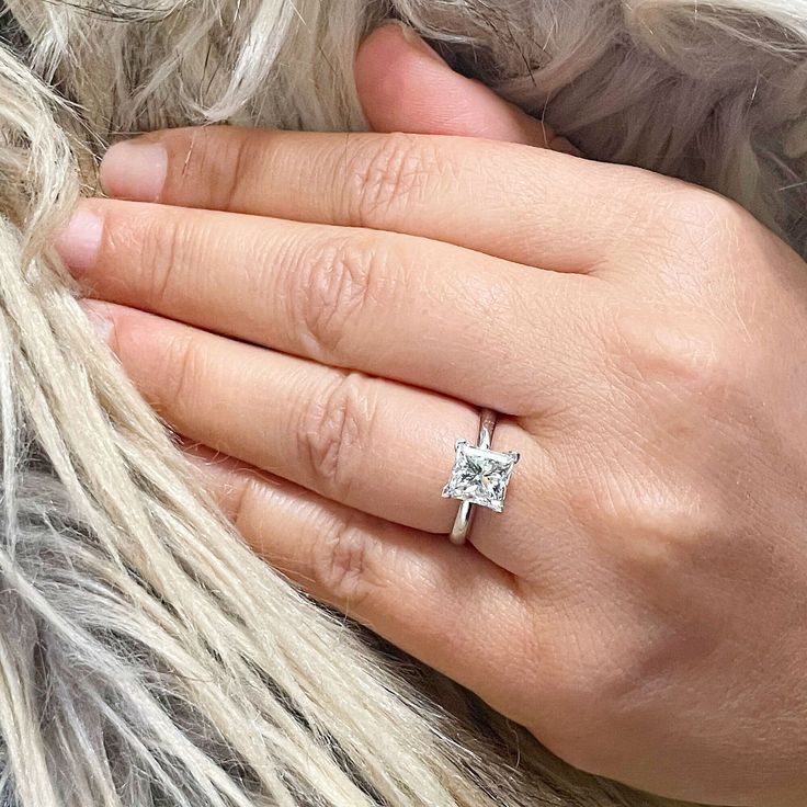 a woman's hand with a diamond ring on it