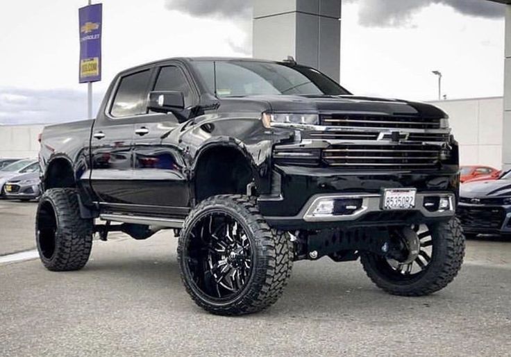 a large black truck parked in a parking lot