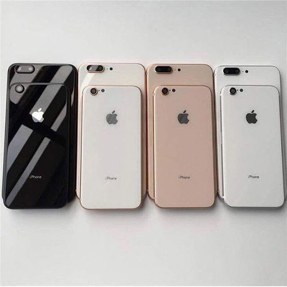 four iphones are lined up next to each other on a white surface with the same color