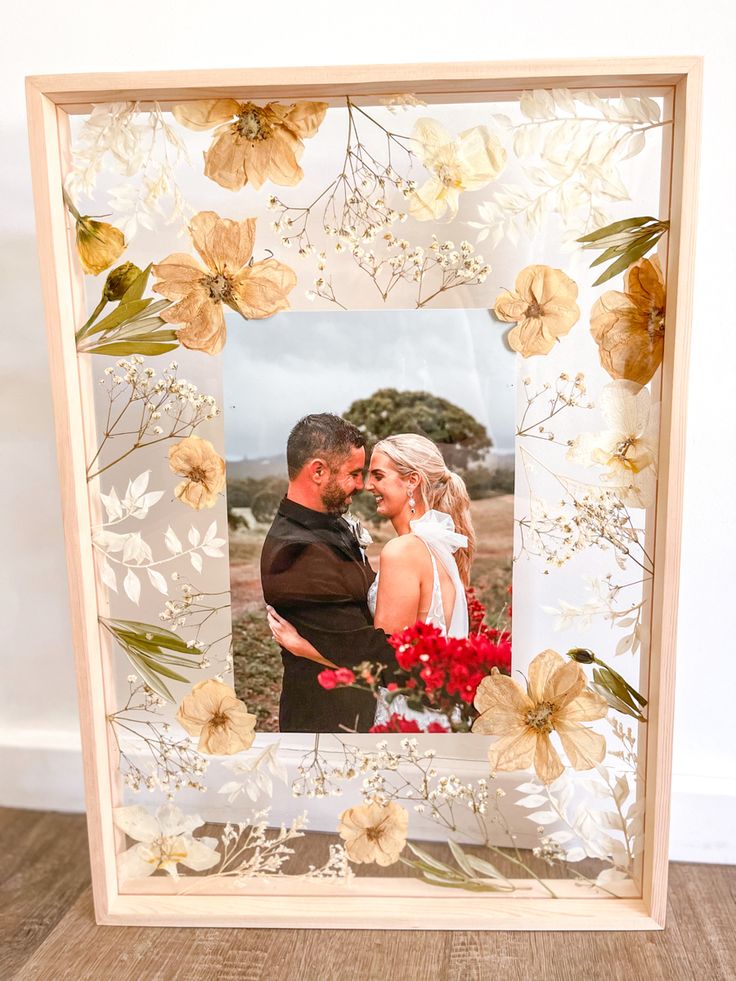 a wedding photo frame with flowers and leaves on the front is shown in an image