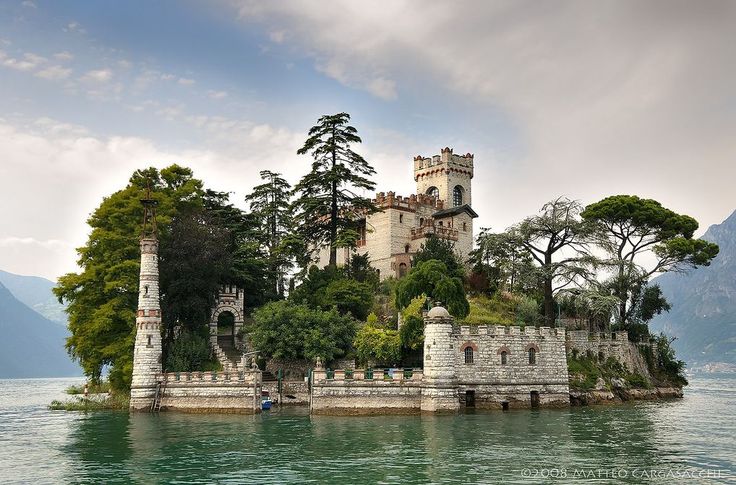 an island with a castle on it in the middle of lake comoni, italy