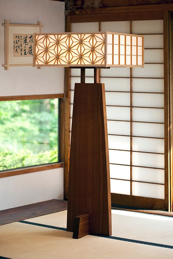 a lamp that is sitting on top of a wooden stand in front of a window