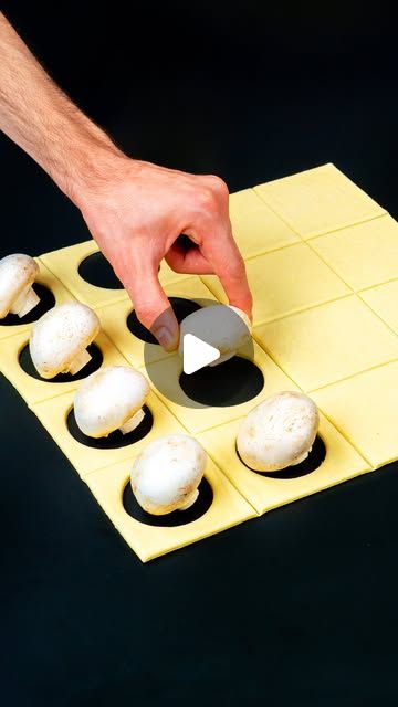 a person is placing marshmallows on top of each other in a tray