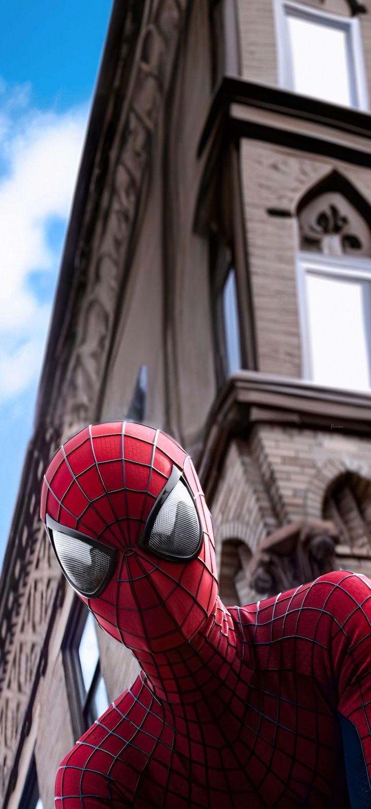 a close up of a spider man in front of a building with a sky background