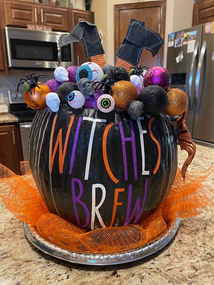 a witches brew pumpkin decorated with halloween decorations