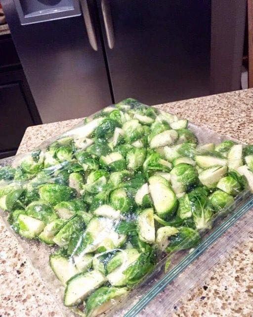 a glass dish filled with brussel sprouts on top of a counter