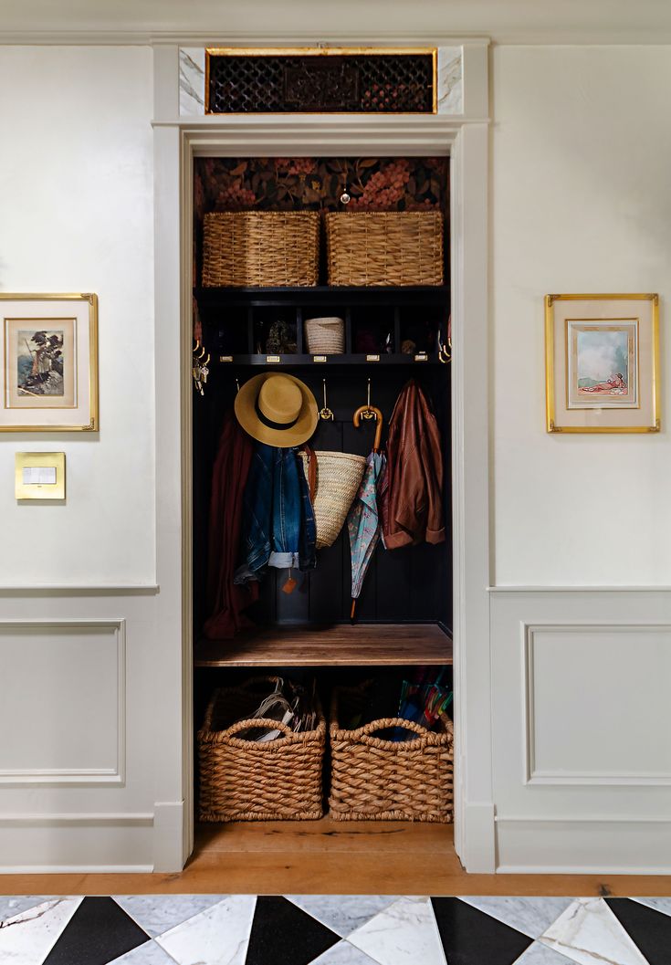 an open closet with baskets and clothes hanging on the wall, next to a black and white checkered floor