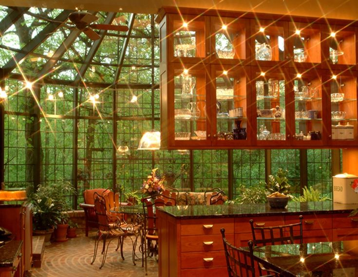 an open kitchen and dining room with lots of lights on the windows over the table