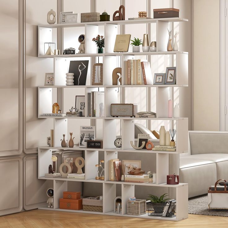 a living room filled with lots of furniture and bookshelves next to a white couch