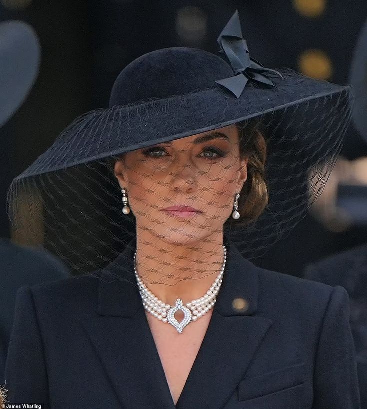 a woman wearing a black hat with a veil on it