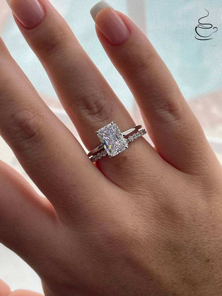 a woman's hand with a diamond ring on it