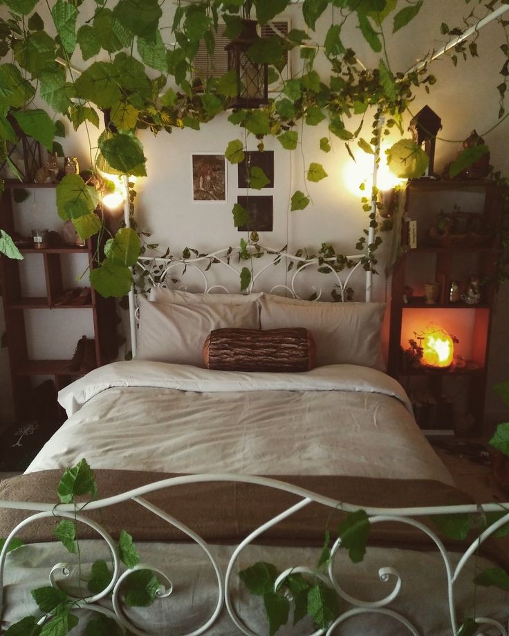 a bed with lots of green plants growing on the headboard and foot board above it