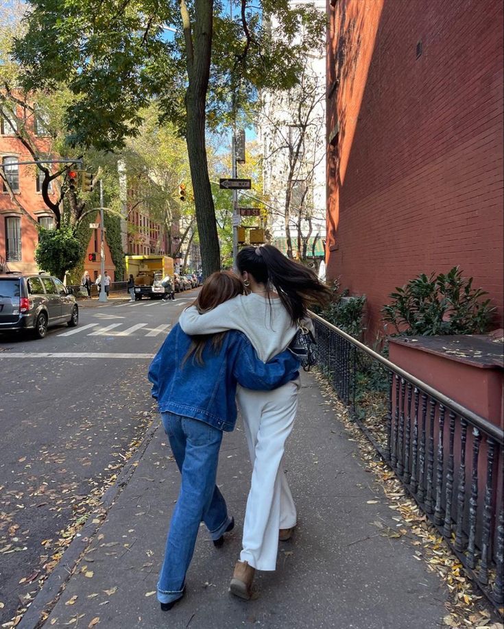 two women are walking down the street together