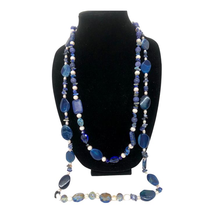 This stunning necklace measures 35 inches and features blue lapis lazuli, complemented with pearls, crystals, and iridescent stones. According to the Sumerians, the lapis lazuli stone housed the spirit of their gods, while the ancient Egyptians regarded it as a representation of the night sky. Lapis lazuli has always been connected to qualities such as strength, courage, intelligence, truth, royalty, and wisdom since ancient times. This necklace can brighten up any room with its bedazzling sparkle. Wrap it three times with the lighter-colored stones at the bottom. Sapphire Beaded Necklaces With Natural Lapis Lazuli Stones, Blue Lapis Lazuli Necklaces With Stones, Blue Lapis Lazuli Stone Necklace, Blue Lapis Lazuli Necklace With Stones, Bohemian Blue Pearl Necklace With Gemstone Beads, Blue Bohemian Pearl Necklace With Gemstone Beads, Blue Gemstone Beads Long Necklace Gift, Blue Long Necklace With Natural Stones For Gift, Blue Long Necklace With Natural Stones As Gift