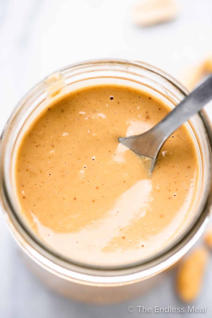 a spoon in a jar filled with peanut butter