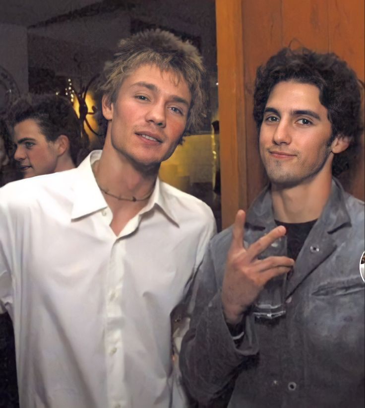 two young men standing next to each other in front of a mirror with the caption's name on it