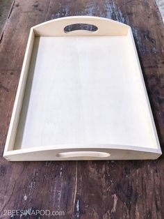 an empty wooden tray sitting on top of a wooden table