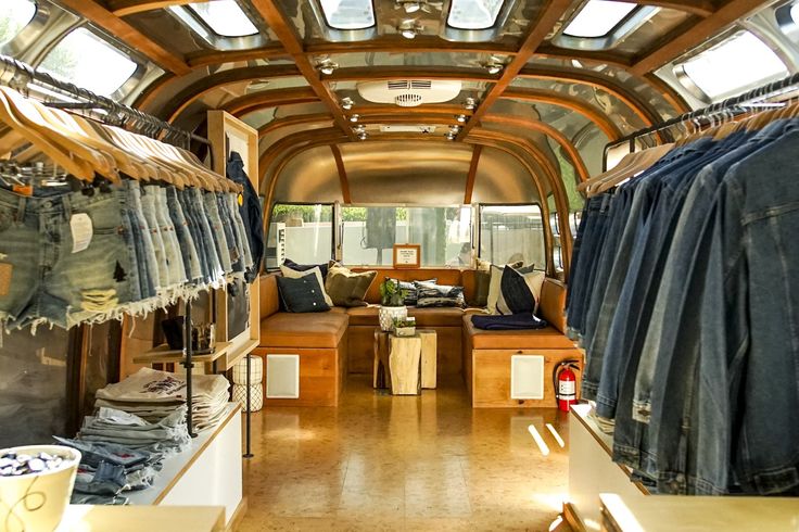 the inside of an rv with clothes hanging on racks