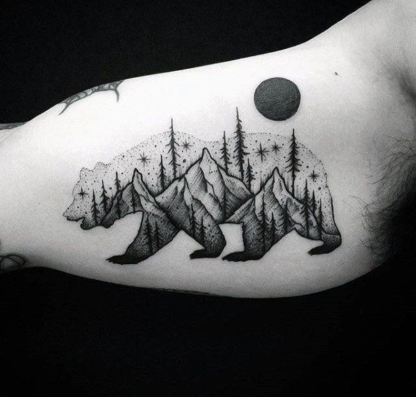 a man's arm with a bear and mountains tattoo on it