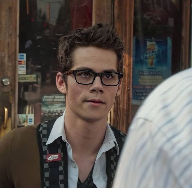 a young man wearing glasses and a vest