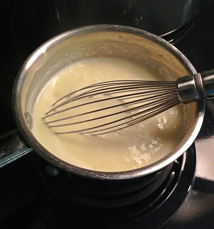 the whisk is being stirred into the liquid in the pot on the stove