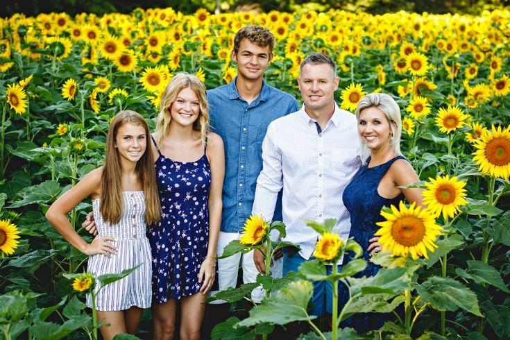 a family standing in the middle of a sunflower field