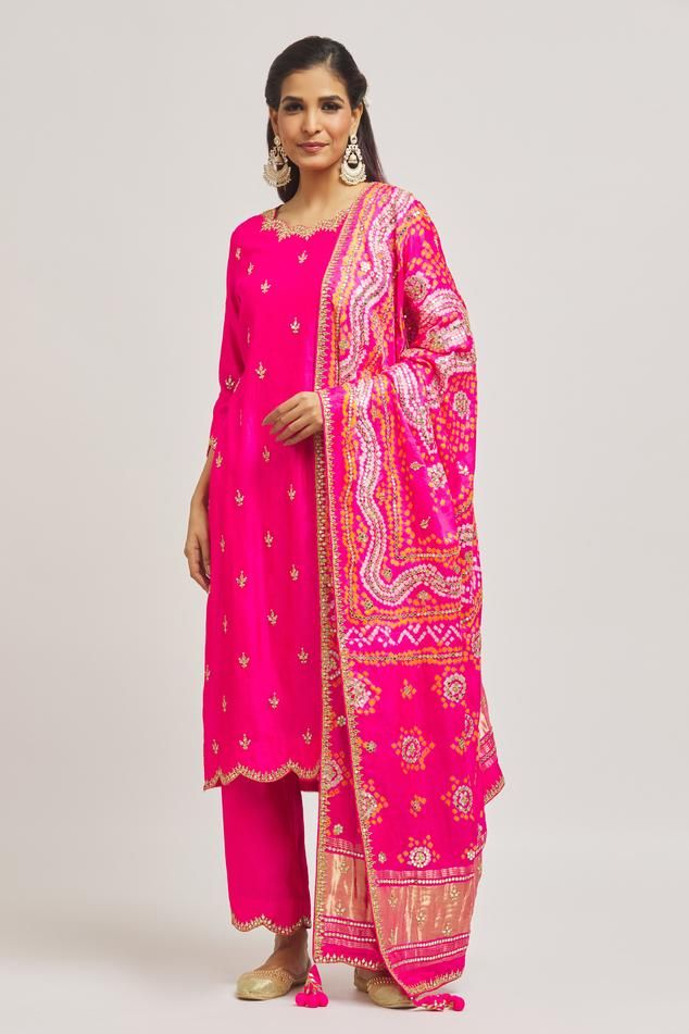 Rani pure spun silk kurta with gota and mirror hand embroidery. Comes with pant and a pure organza dupatta.
Components: 3
Pattern: Hand embroidered
Type Of Work: Gota, Mirror
Neckline: Scalloped Neck
Sleeve Type: Three quarter
Fabric: Pure satin organza
Color: Pink
Other Details: 
Side slits on kurta
Embroidered borders on dupatta
Occasion: Mehendi and Haldi - Aza Fashions Unstitched Straight Kurta Palazzo Set With Gota Work, Silk Sets With Resham Embroidery For Navratri, Silk Traditional Wear With Gota Work For Festivals, Festive Kurta With Mirror Work In Slub Silk, Festive Slub Silk Kurta With Mirror Work, Raw Silk Unstitched Suit With Mirror Work, Designer Unstitched Slub Silk Suit With Dori Work, Unstitched Raw Silk Suit With Mirror Work, Navratri Chanderi Palazzo Set With Resham Embroidery