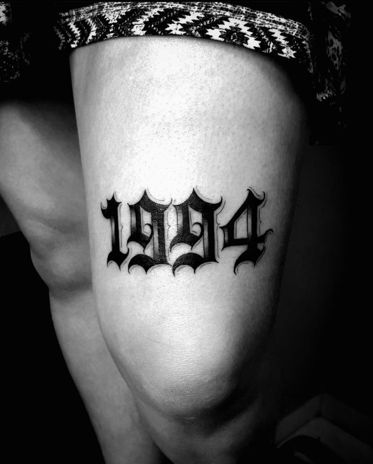 a woman with a tattoo on her leg and the word d is spelled in black ink