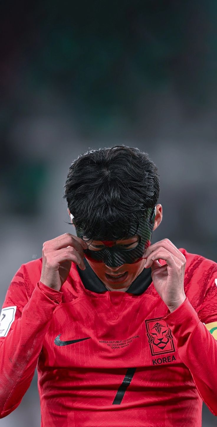 a soccer player is covering his face with his hands