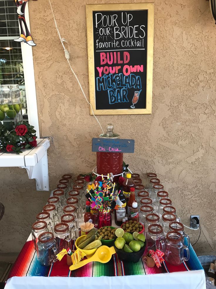 a table covered with lots of food and drinks next to a sign that says build your own margarita bar