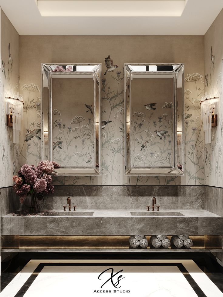 a bathroom with two sinks and mirrors in it's wallpapered walls, along with flowers on the counter