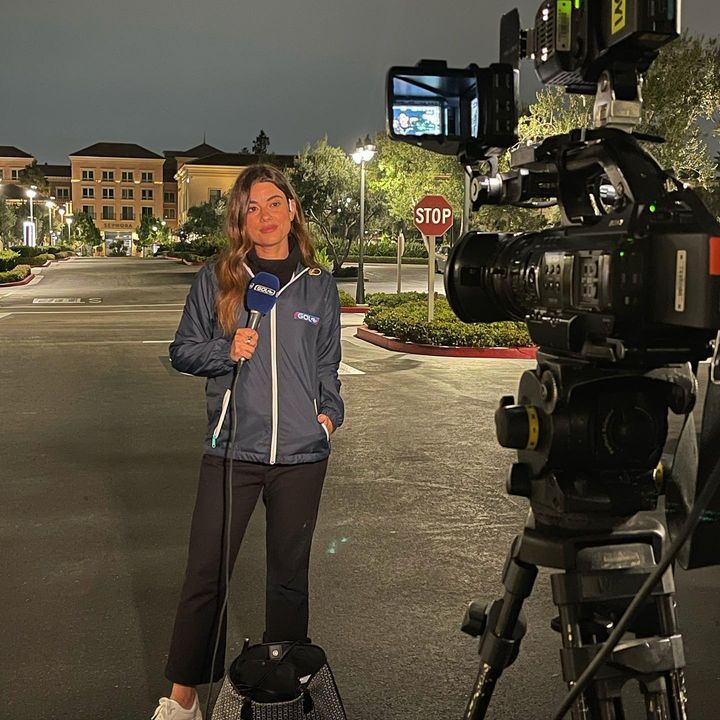 a woman standing in the middle of a street with a camera on her tripod