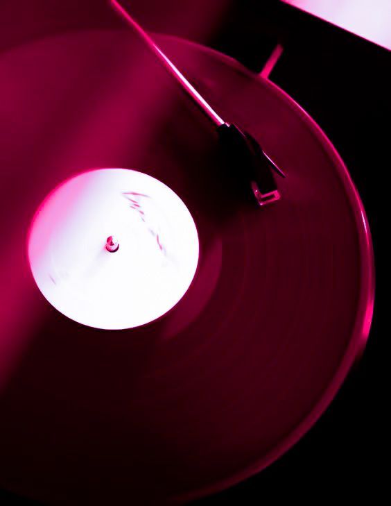 a record player's turntable with a red light shining on the disc cover