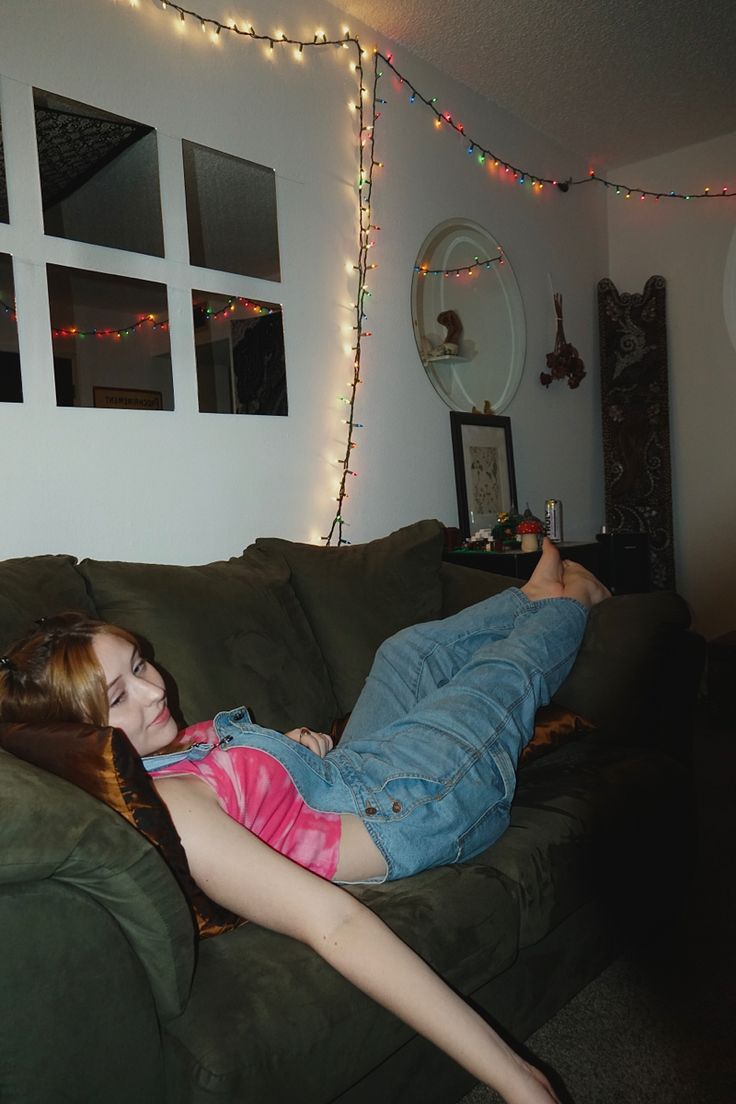 a woman laying on top of a green couch