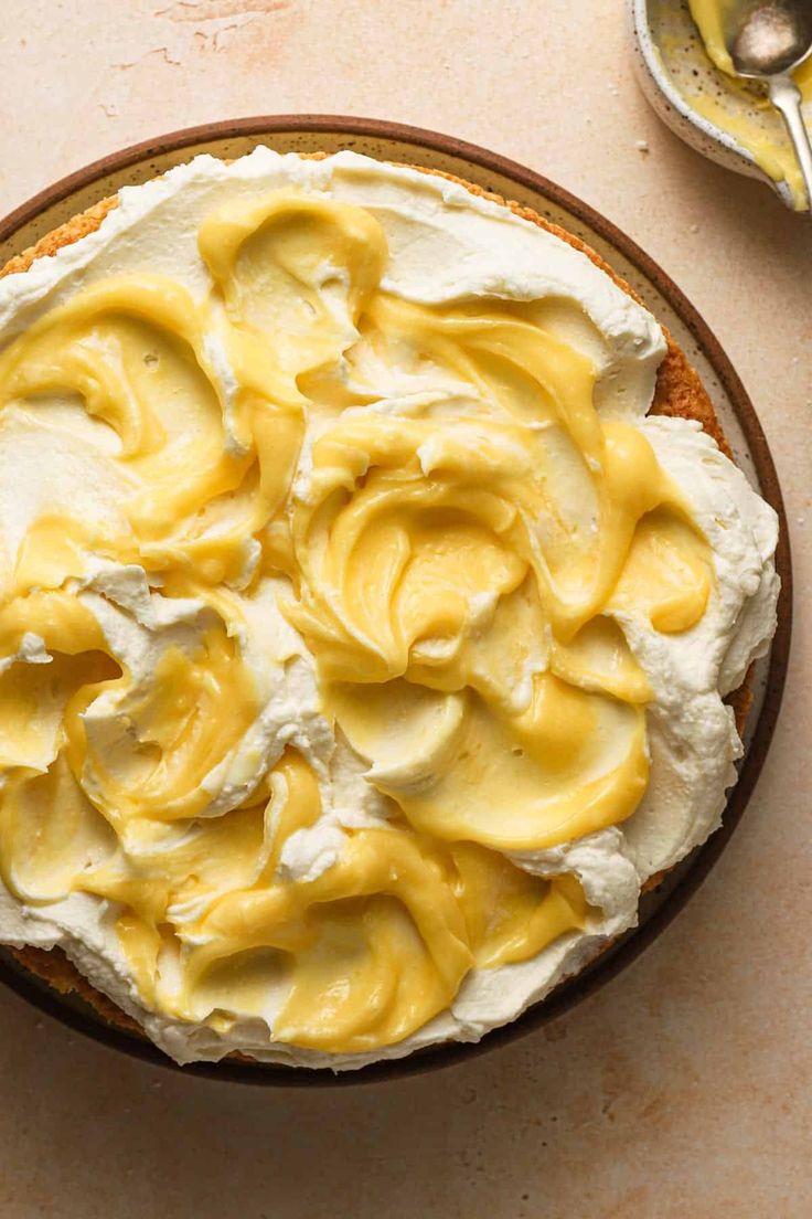 a cake with yellow icing in a bowl on a table