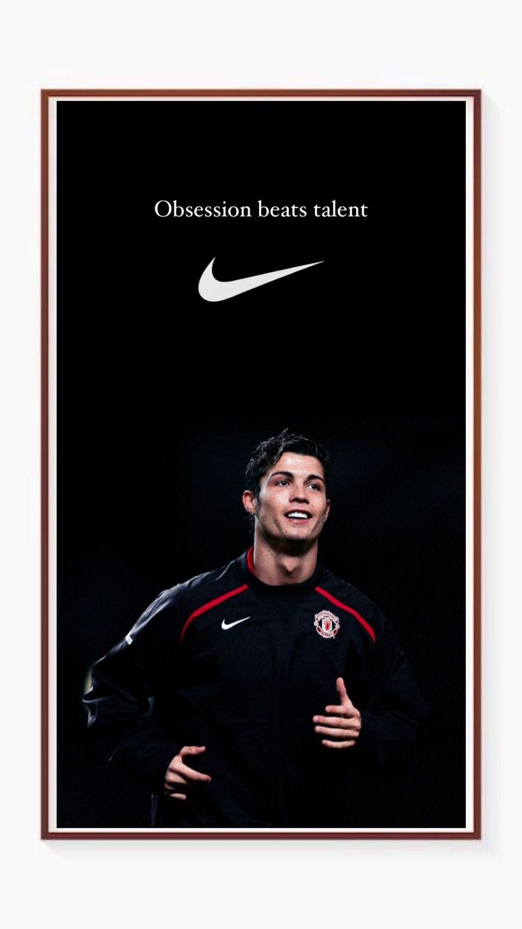 a man in black jacket standing next to a poster with the words obsesion beats talent