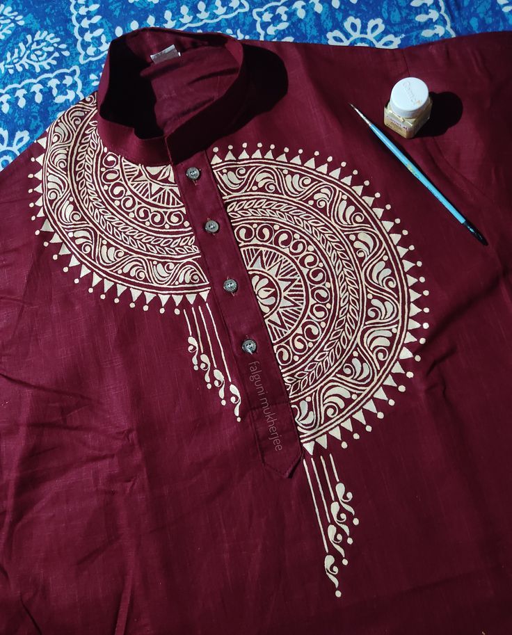 the shirt is red and white with an intricate design on it, along with a brush