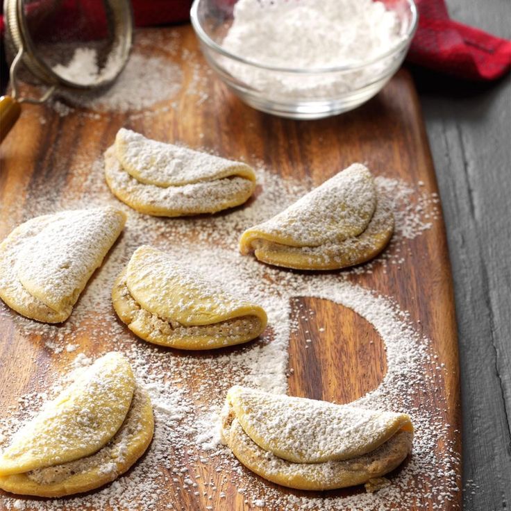 some cookies are on a wooden board with powdered sugar