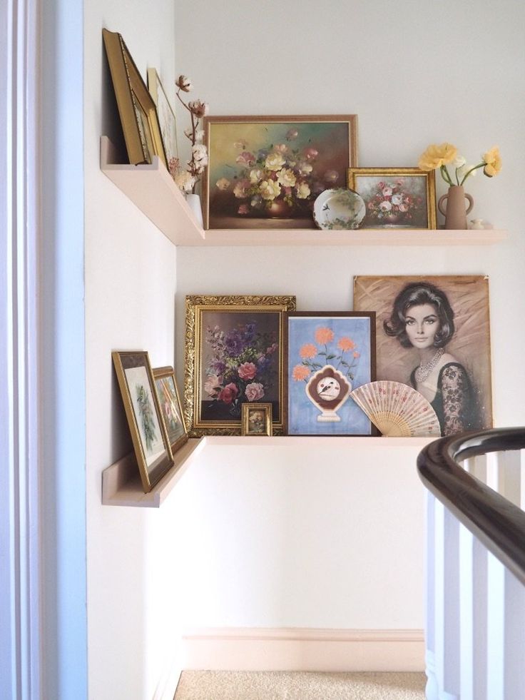 some shelves with pictures and paintings on them